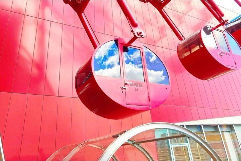 A red cable car with a clear sky reflected in its windows. 2