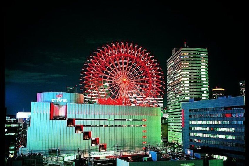 A large Ferris wheel, a modern building with a blue facade, and a skyscraper in the background. 5