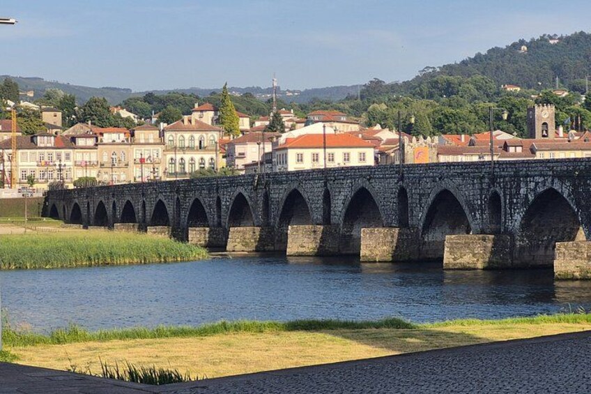A stone bridge over a river with a town in the background. 5