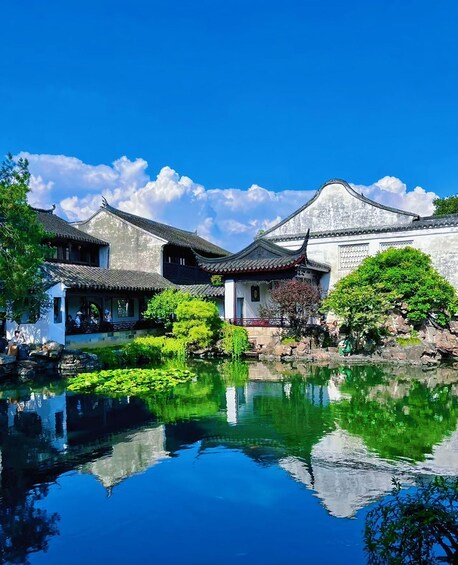 Traditional Chinese architecture, a calm pond, and a clear blue sky. 1