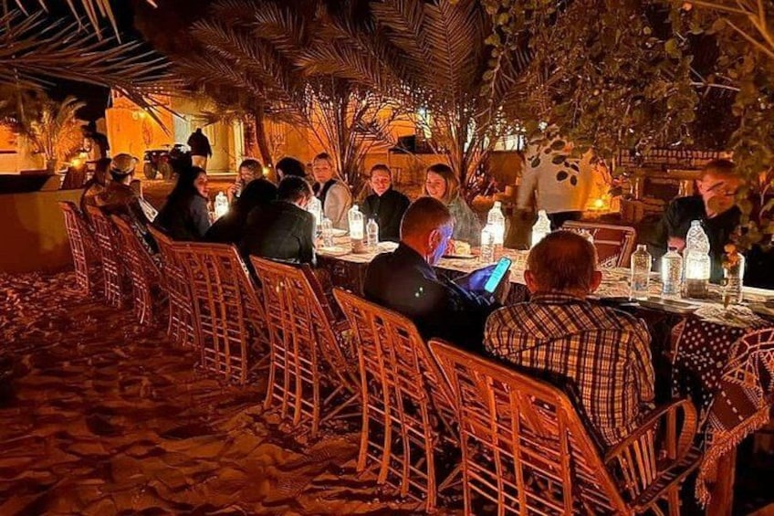 A restaurant with outdoor seating, tables, chairs, and people dining. 2