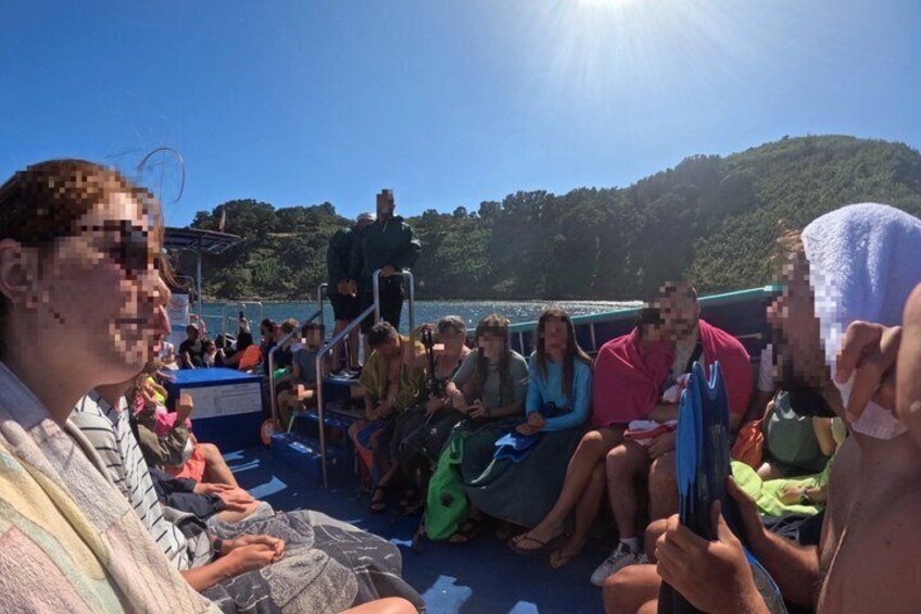 People on a boat with a mountainous landscape in the background. 5