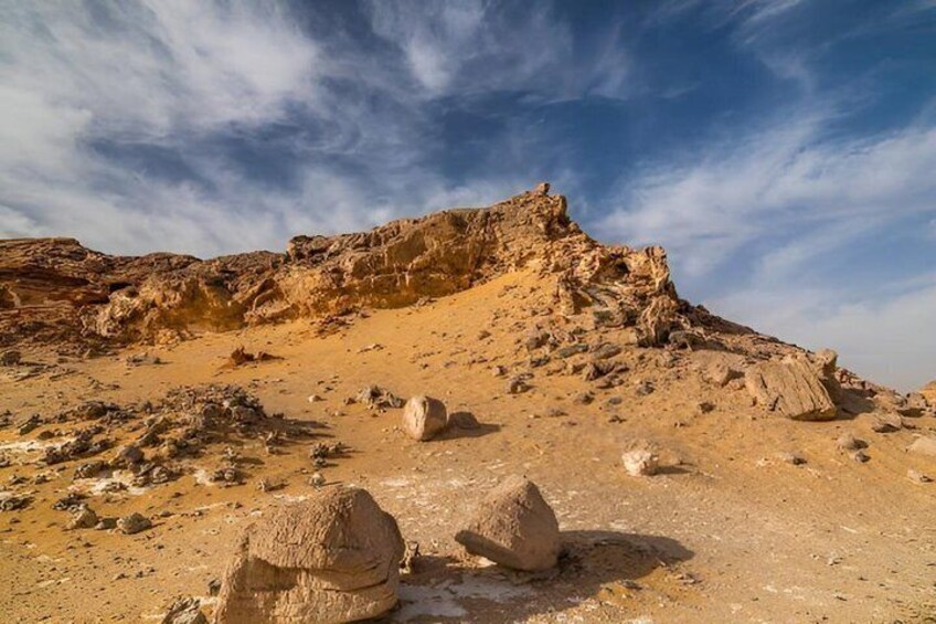 A desert landscape with rocky terrain and a prominent hill. 4