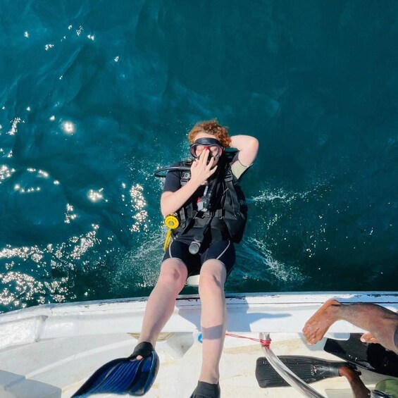 A person scuba diving with a diving mask and a black wetsuit. 3