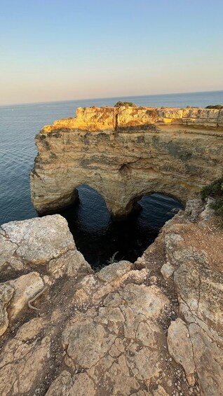 A coastal cliff with a cave entrance and a view of the sea. 4