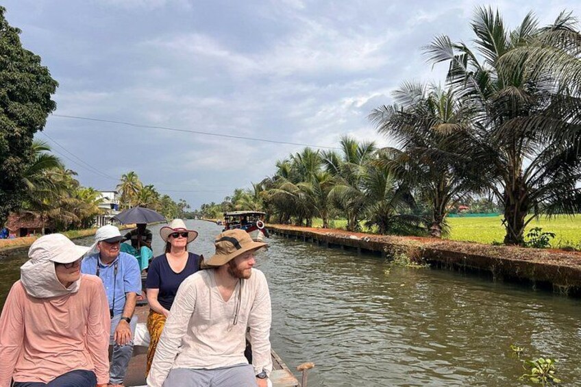 A group of people on a narrow waterway surrounded by palm trees. 4