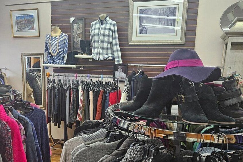 A clothing store with racks of clothes and boots. 3