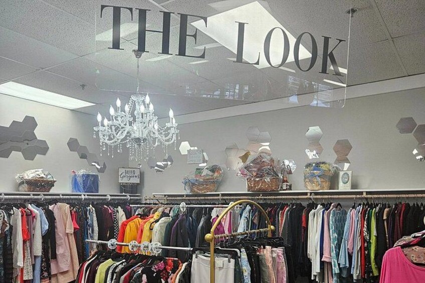 A clothing store interior with racks of clothes, a chandelier, and a sign that reads 'THE LOOK'. 2