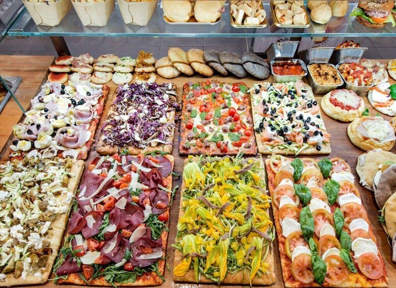 A variety of pizzas and sandwiches displayed on a counter. 4