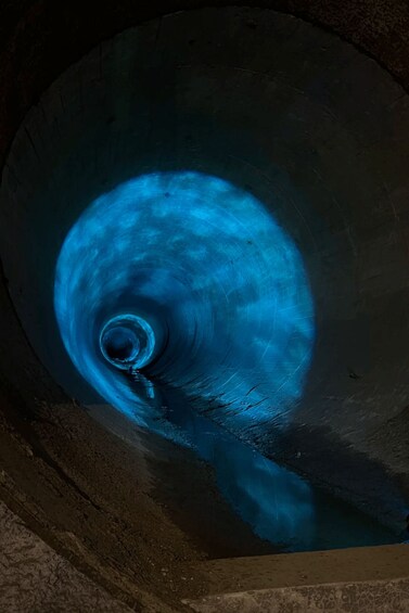 A blue-lit spiral structure, possibly a tunnel or shaft, with rough, earthy walls. 3