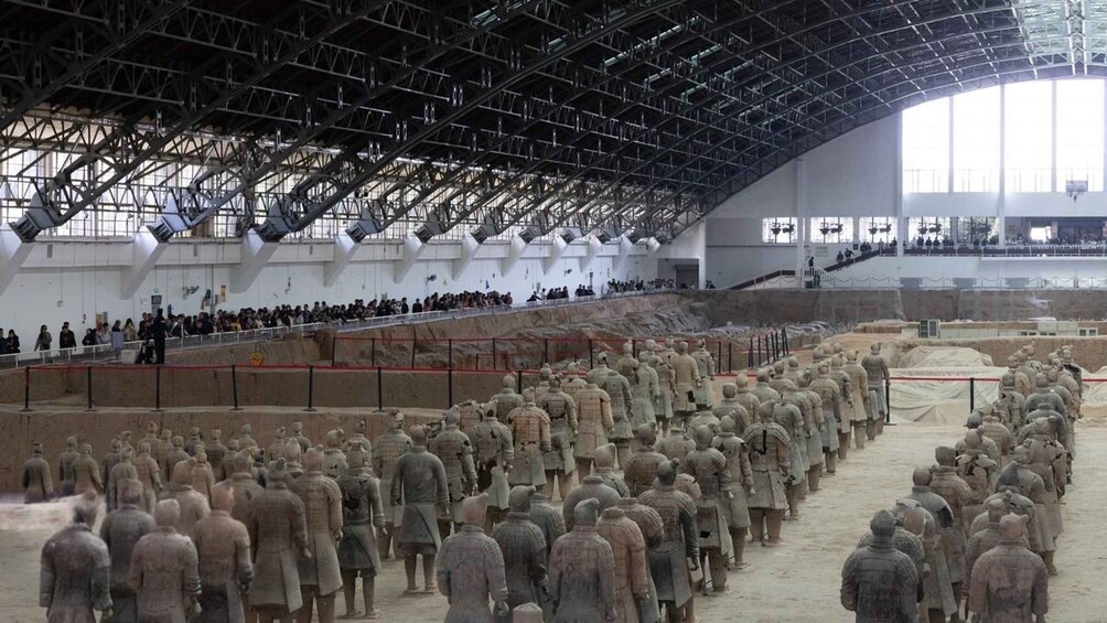 A large indoor display of terracotta soldiers arranged in a formation. 3
