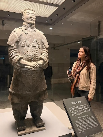 A museum exhibit featuring a large statue of a historical figure in armor, with a descriptive plaque. 1