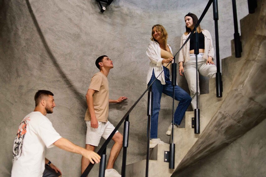 People ascending a concrete staircase with metal railings. 2