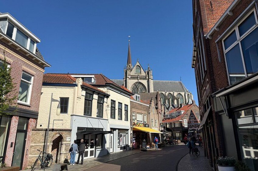 A street with buildings, a church, and a bicycle. 3