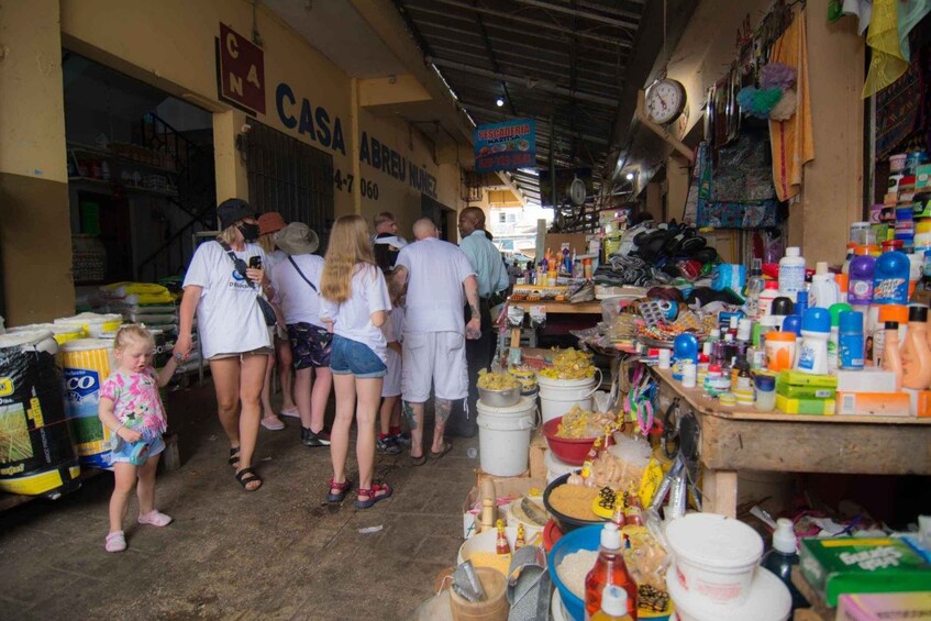 A crowded indoor market with various stalls selling goods. 1