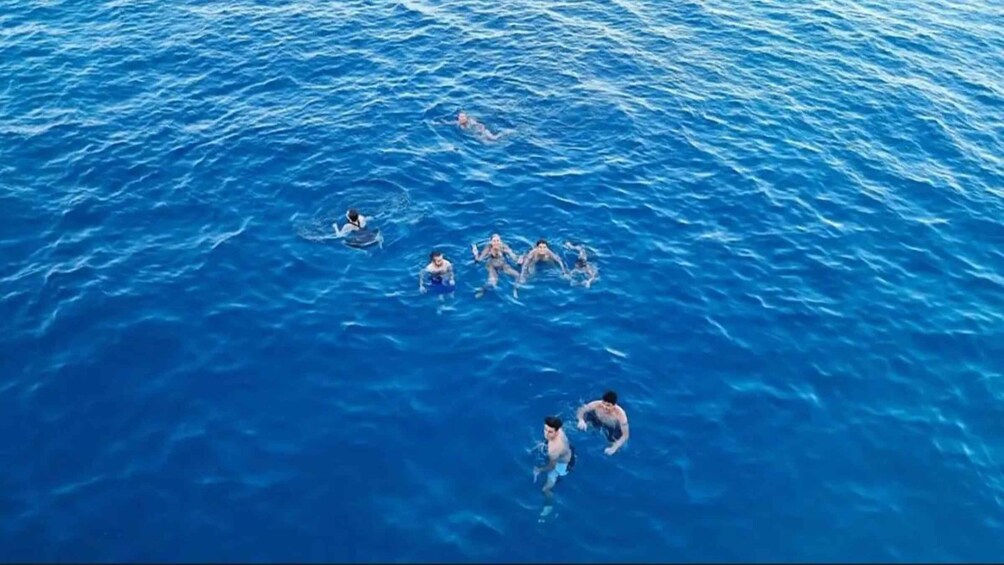 A group of people swimming in a large body of water. 4