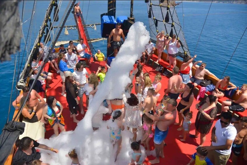 A group of people on a boat with a large white foam structure in the center. 5