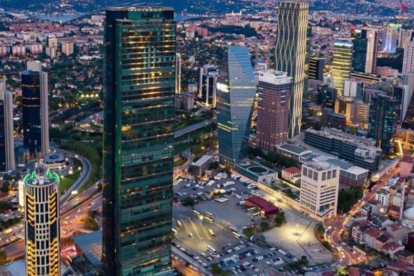 A cityscape with modern skyscrapers, a river, and a roundabout. 1
