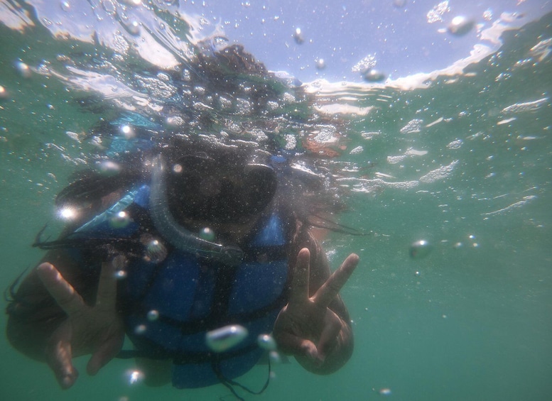 A person underwater with bubbles and sunlight filtering through the water. 3