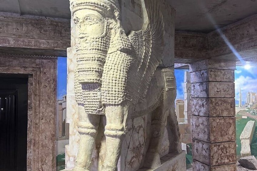 A large stone statue with intricate carvings, set against a backdrop of a building facade. 3