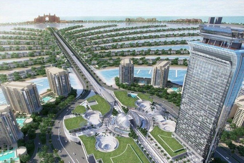 A modern urban area with high-rise buildings, a waterfront, and a large circular structure. 2
