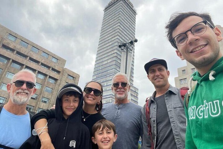 A group of people standing in front of a tall building. 1