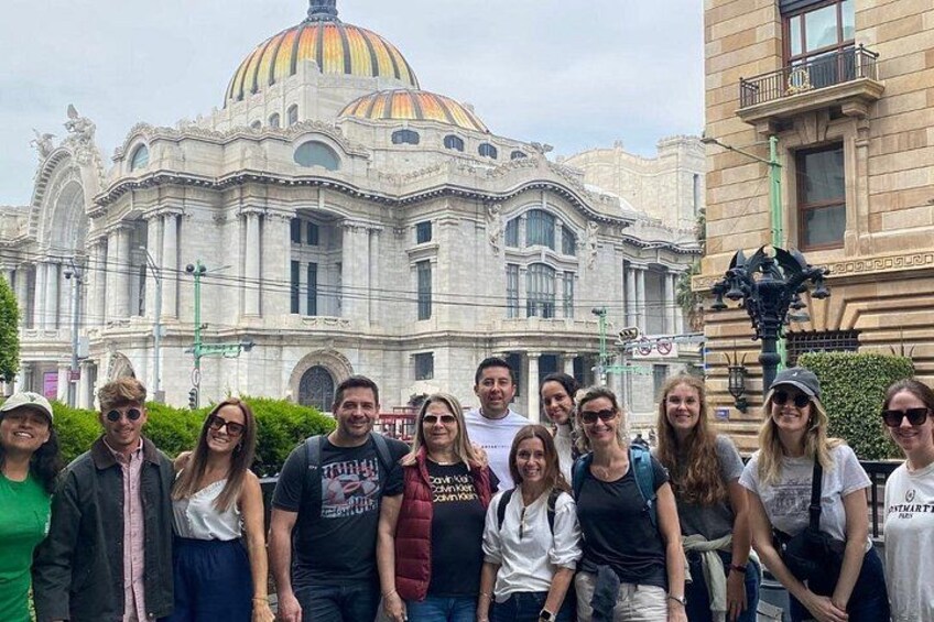 Un grupo de personas frente a un edificio grande y ornamentado con una cúpula destacada. 4