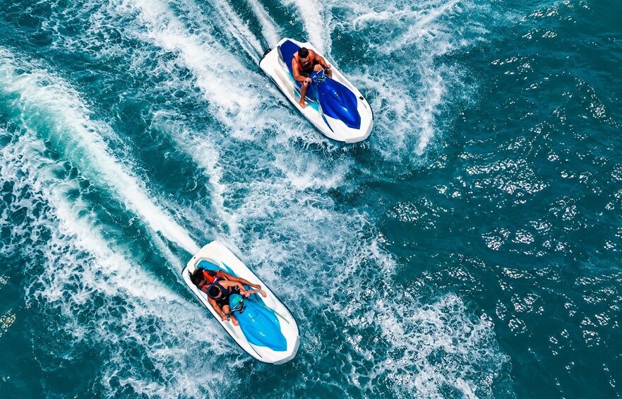 Two jet skis on a body of water with waves. 2