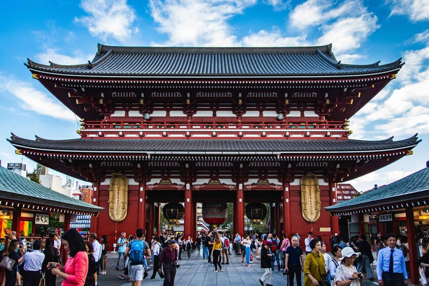A traditional Japanese gate with visitors in front. 5