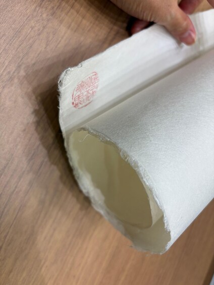 A rolled-up piece of paper with a red stamp on it. 3