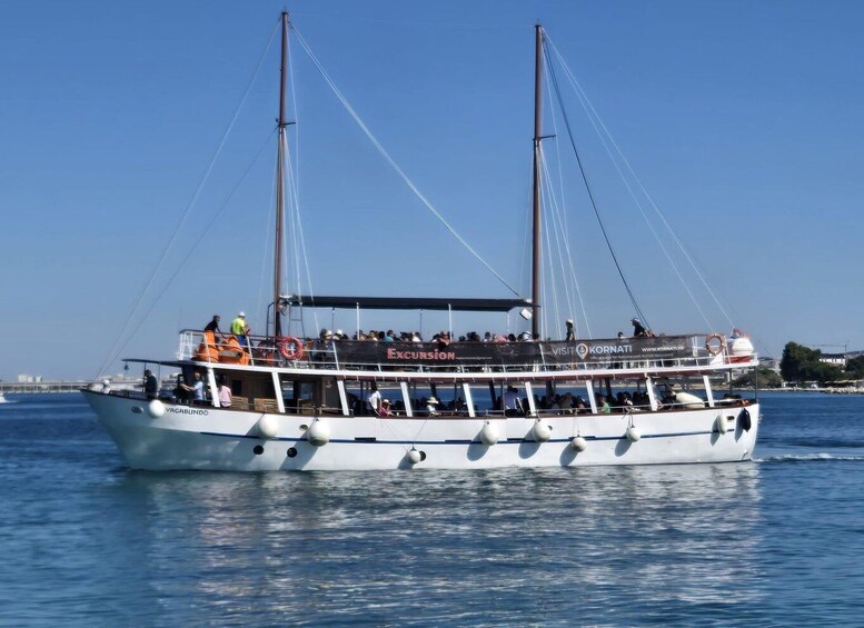 A white boat with multiple masts and passengers, labeled 'VAGABLINDO,' sailing on water. 4