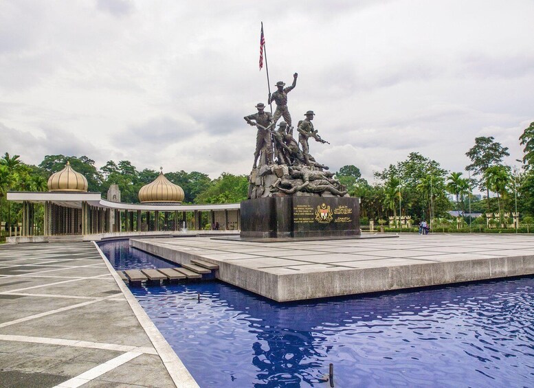 A memorial with a statue, a pool, and a mosque-like structure. 4