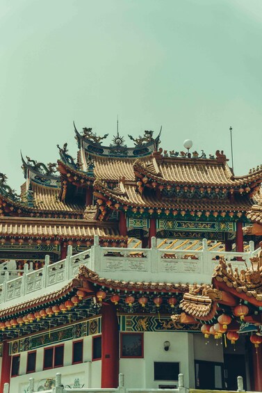 A traditional multi-tiered temple roof with ornate decorations and red pillars. 3