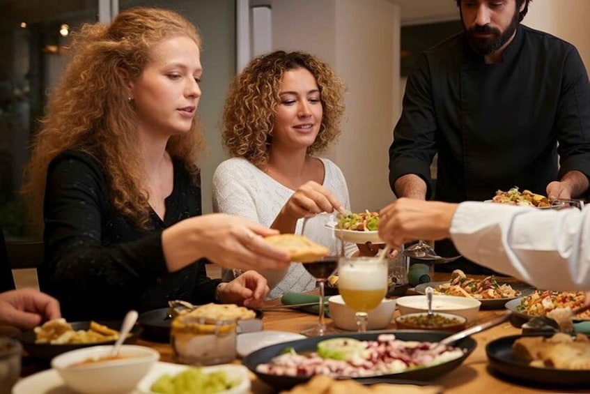 A group of people dining at a restaurant with various dishes and drinks on the table. 5