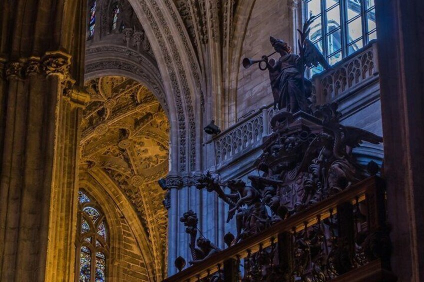 An ornate cathedral interior with detailed stone carvings and a large stained glass window. 5
