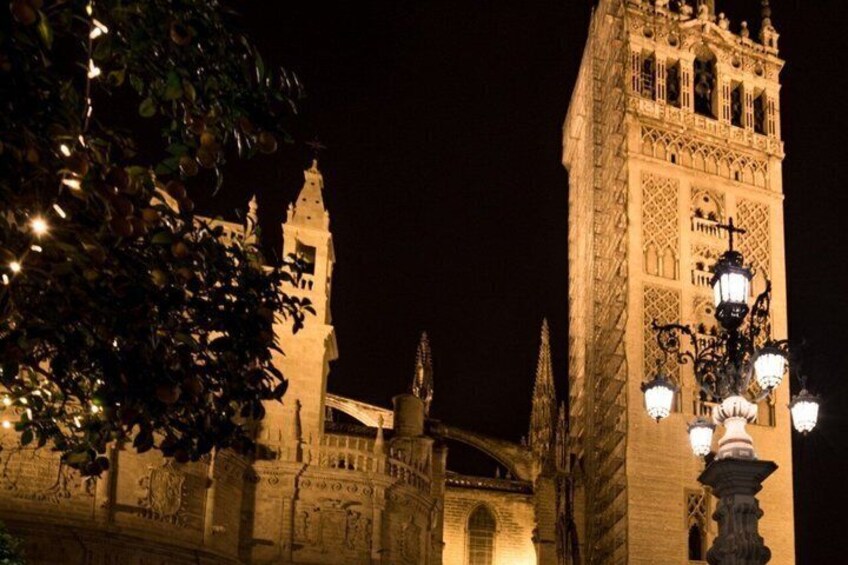 A historic building with ornate architecture and a tower, illuminated at night. 1