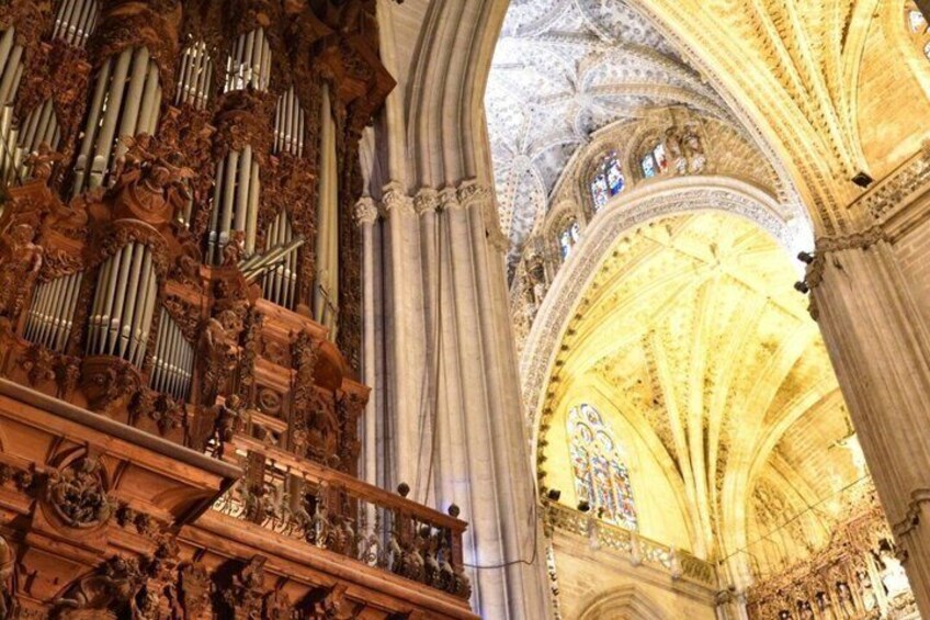A cathedral interior with ornate pipe organs and a vaulted ceiling. 4