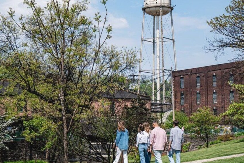 A water tower, a brick building, and a group of people walking. 2