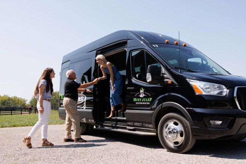 A black van with 'JULER' branding parked on a road with people getting in and out. 3