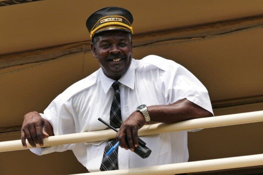 A man in a white shirt and black tie, wearing a cap with 'CONDUCTOR' on it, holding onto a railing. 2