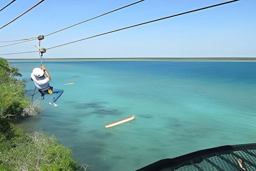 Eine Person zipline über ein Gewässer. 1