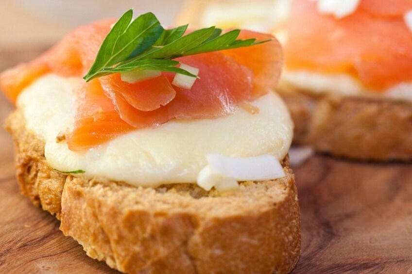 A sandwich with smoked salmon and cream cheese on a slice of bread. 2