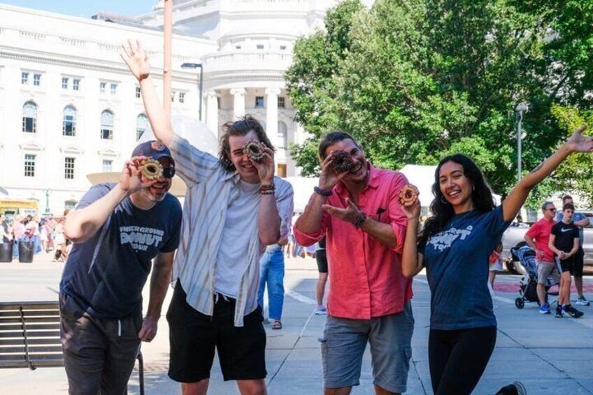 A group of people posing for a photo in an outdoor setting with a building in the background. 2