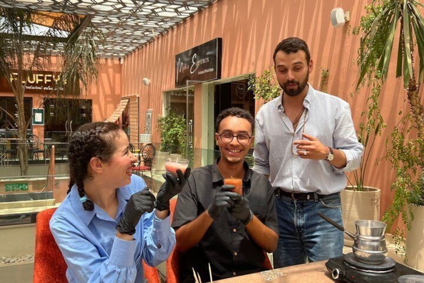 Three people at an outdoor café with a modern building in the background. 3