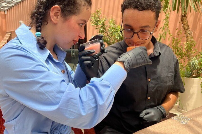 Two individuals in a laboratory setting, one wearing a light blue shirt and the other in a black shirt, handling a test tube. 4