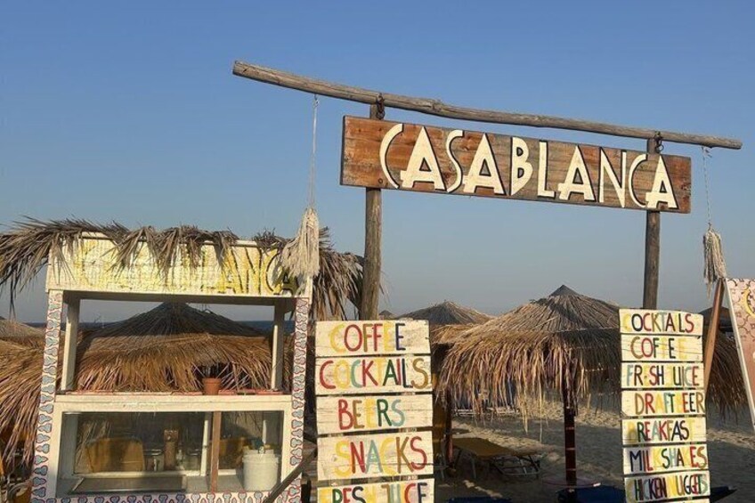 A beachside sign for 'CASABLANCIA' with multiple drink options listed. 3
