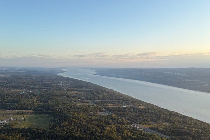 A river winding through a densely forested landscape with a clear sky above. 5