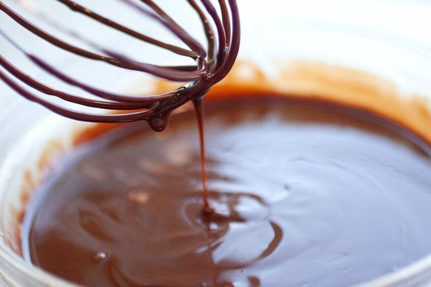 A whisk mixing chocolate in a bowl. 5