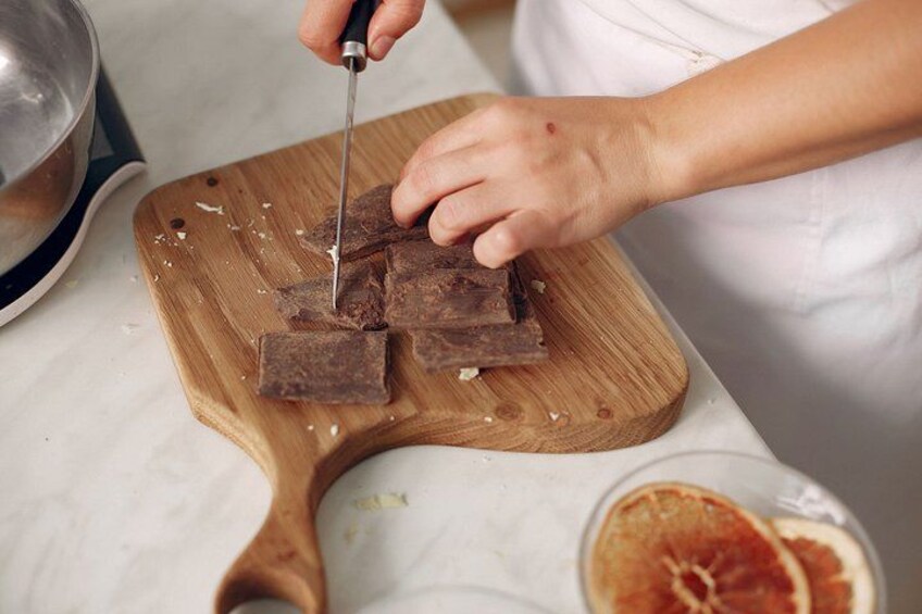 A person cutting a piece of meat on a wooden cutting board. 3