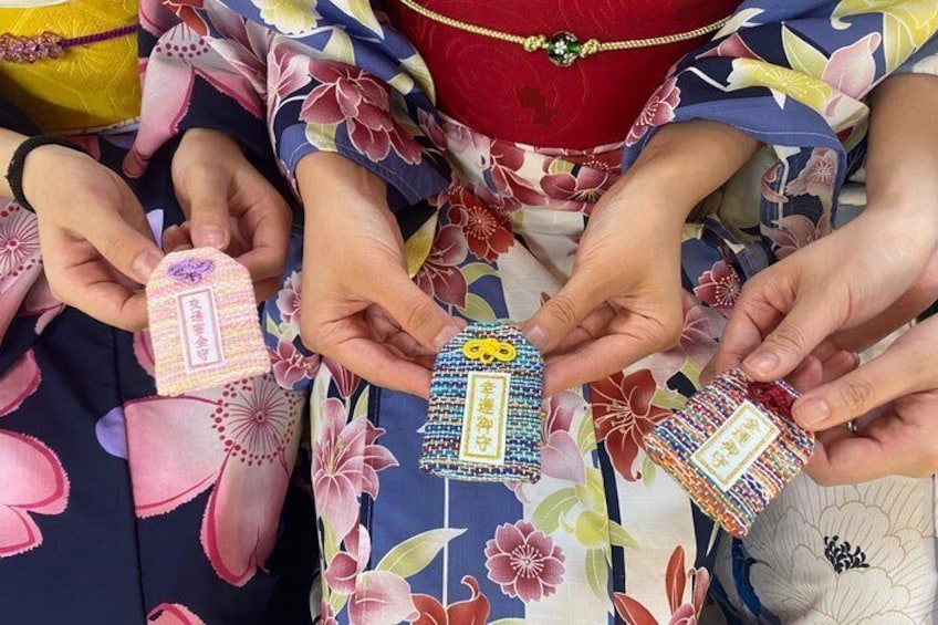 Three individuals holding decorative items with intricate patterns and text. 1